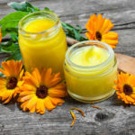 Homemade calendula ointment on wooden table
