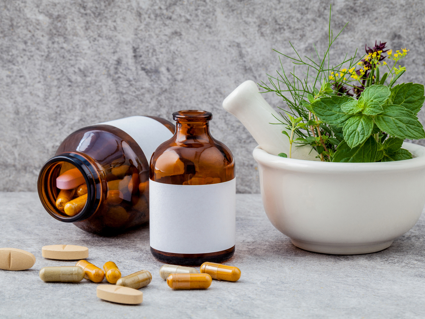 Alternative health care fresh herbs rosemary ,lemon thyme ,fennel ,peppermint ,basil flower and herbal capsule with mortar on stone background.