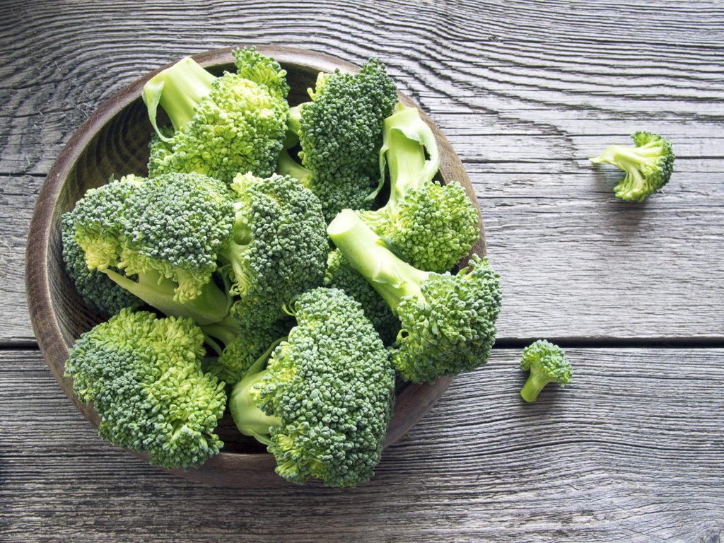Raw broccoli in a bowl on rustic background