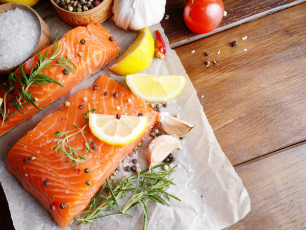 Raw salmon fillet with rosemary pepper sweetbread and salt on baking paper rustic theme with copy-space