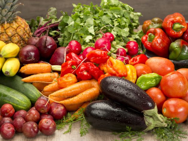 Fresh organic vegetables and fruits on wood table. Horizontal composition.