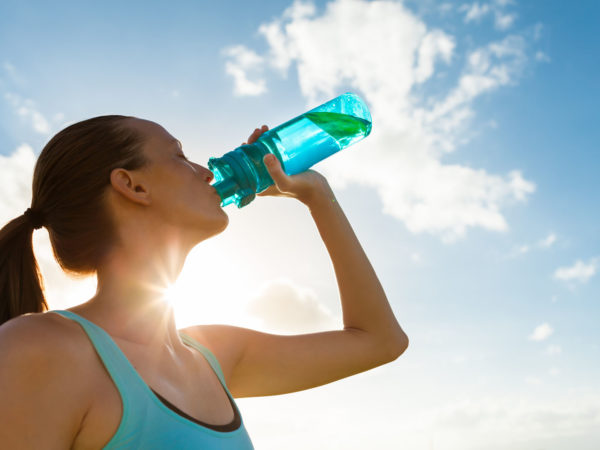 Female drinking a fresh water from bottle.