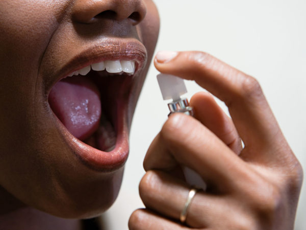 Woman using breath freshener