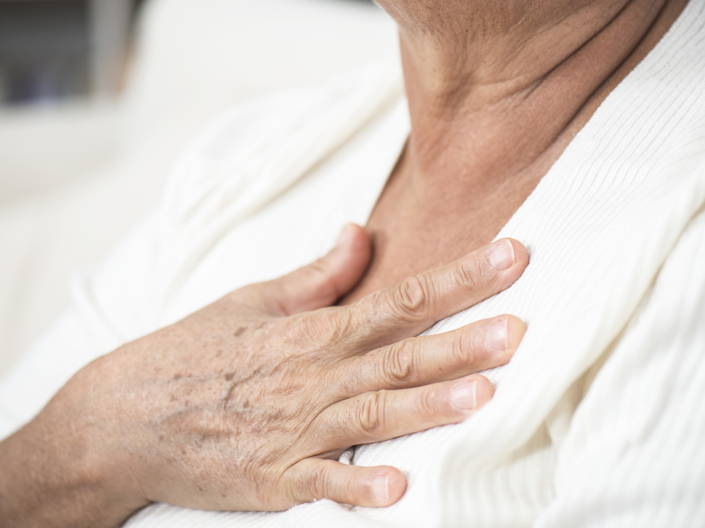 Senior woman feeling unwell, touching her chest.