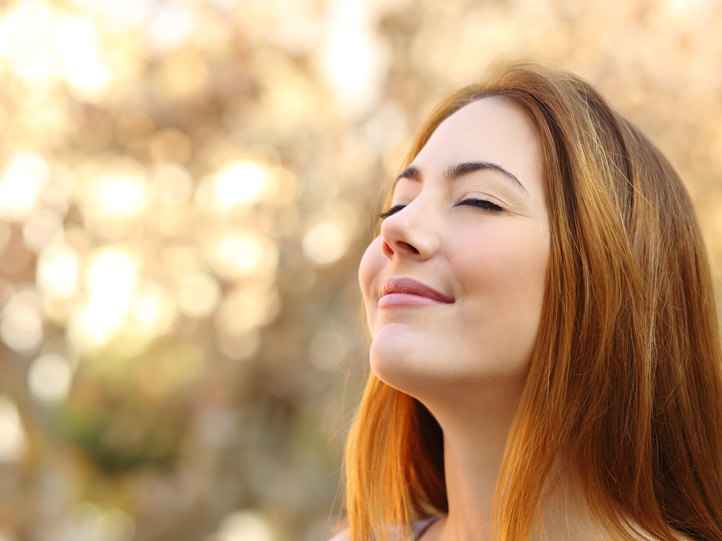 Portrait of a beautiful woman doing breath exercises with an autumn unfocused background