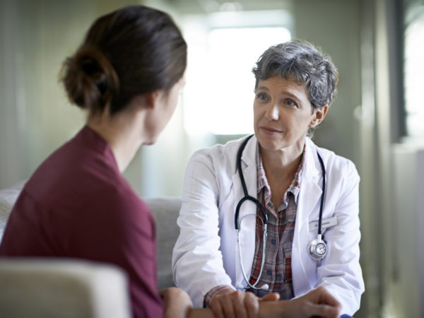 Shot of a compassionate doctor comforting a young woman in a hospital waiting room