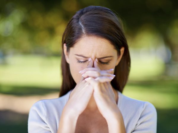 Shot of an attractive young woman looking stressed while standing outdoors