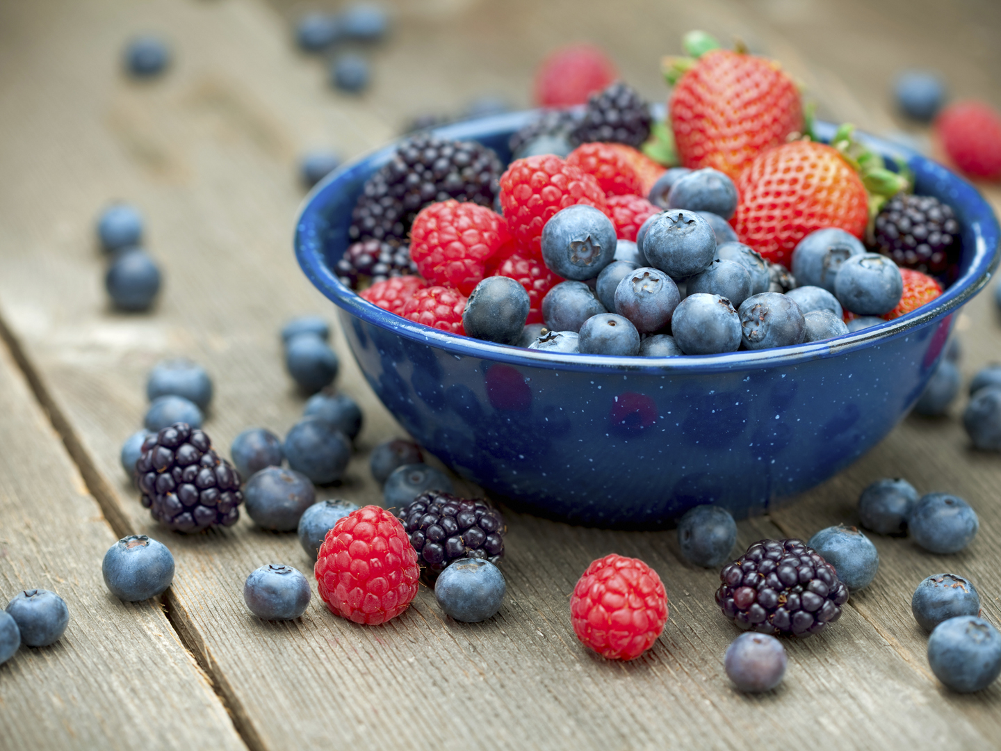 A bowlful of delicious organic berries.  Strawberries, blackberries, blueberries and raspberries.