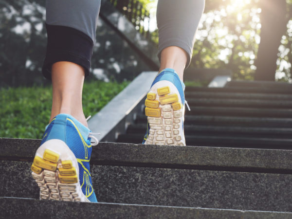 Athlete runner feet running in nature, closeup on shoe. Female athlete running on stairs. Woman fitness, running, jogging, sport, fitness, active lifestyle concept