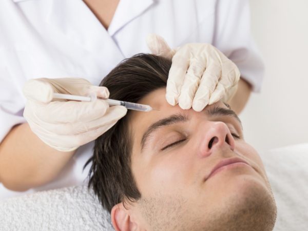 Young Man Having Botox Treatment At Beauty Clinic