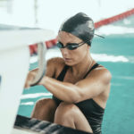 Backstroke swimmer at the swimming block, ready to start the race