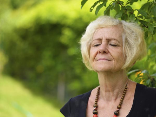 Mature, blonde woman in garden,