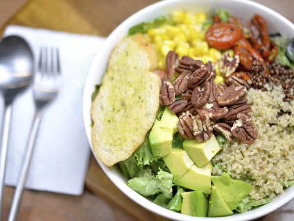 Selective focus of Salad bowl with avocado, almond, quinoa and garlic bread