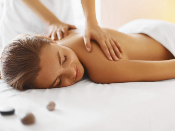 Spa woman. Female enjoying relaxing back massage in cosmetology spa centre. Body care, skin care, wellness, wellbeing, beauty treatment concept.