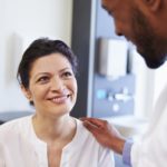 Female Patient Being Reassured By Doctor In Hospital Room