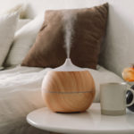 Aromatherapy Concept. Aroma oil diffuser on chair against in the bedroom. Air freshener. Ultrasonic aroma diffuser for home