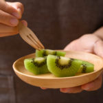 Sliced green kiwi fruit on wooden plate ready to eating, Healthy fruit