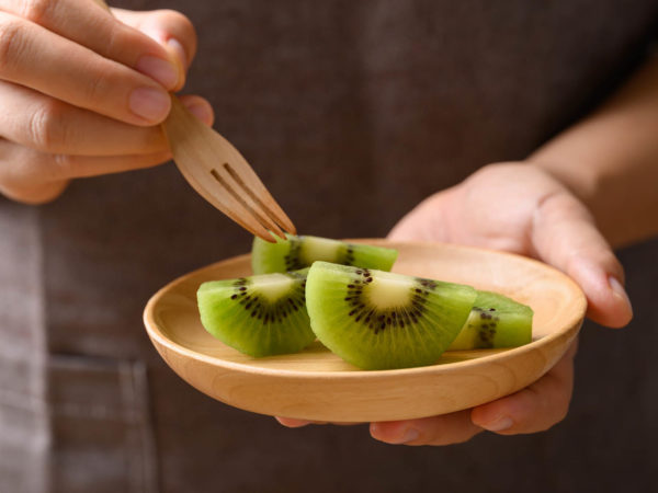 Sliced green kiwi fruit on wooden plate ready to eating, Healthy fruit