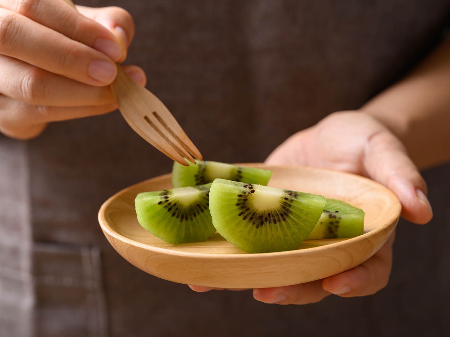 Sliced green kiwi fruit on wooden plate ready to eating, Healthy fruit